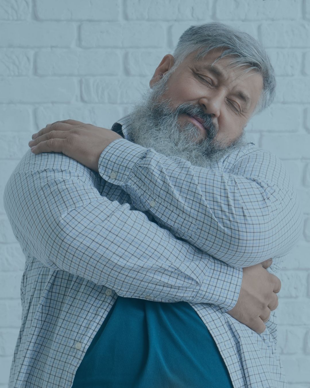 man gives himself a hug demonstrating he give importance to mental health services